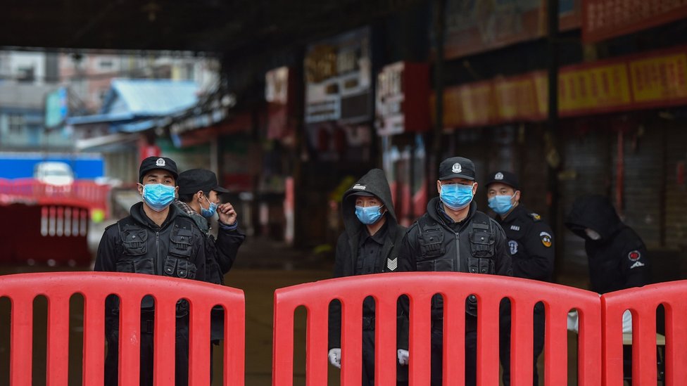Korona virus: Anatomija pandemije respiratorne bolesti Kovid-19 4 Policija ispred pijace Huanan u Vuhanu, za koju se pretpostavlja da je izvor epidemije