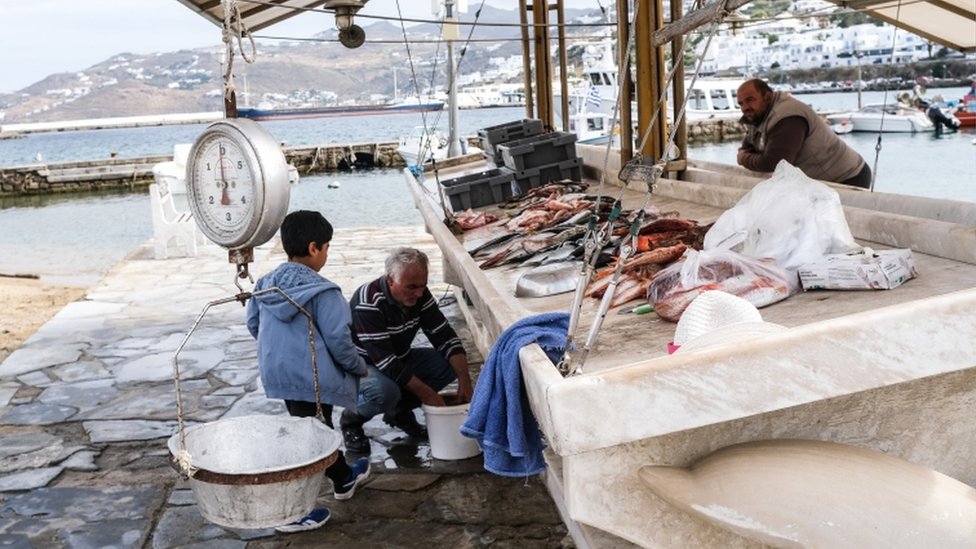 Korona virus, letovanje i Grčka: Da li se turisti vraćaju na ostrva 6 A fisherman cleans fish on May 26, 2020 in Mykonos, Greece