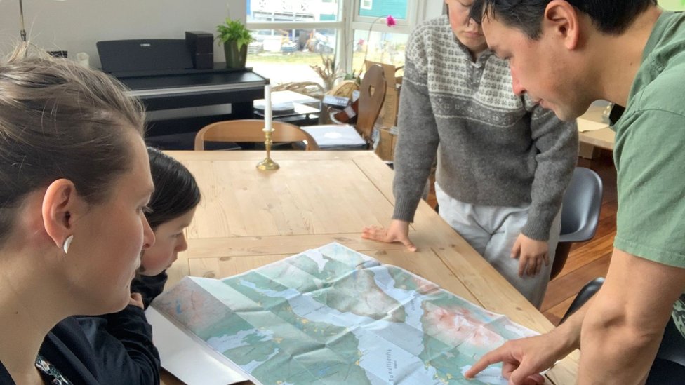 Arnakkuluk Kleist and her family look at a map