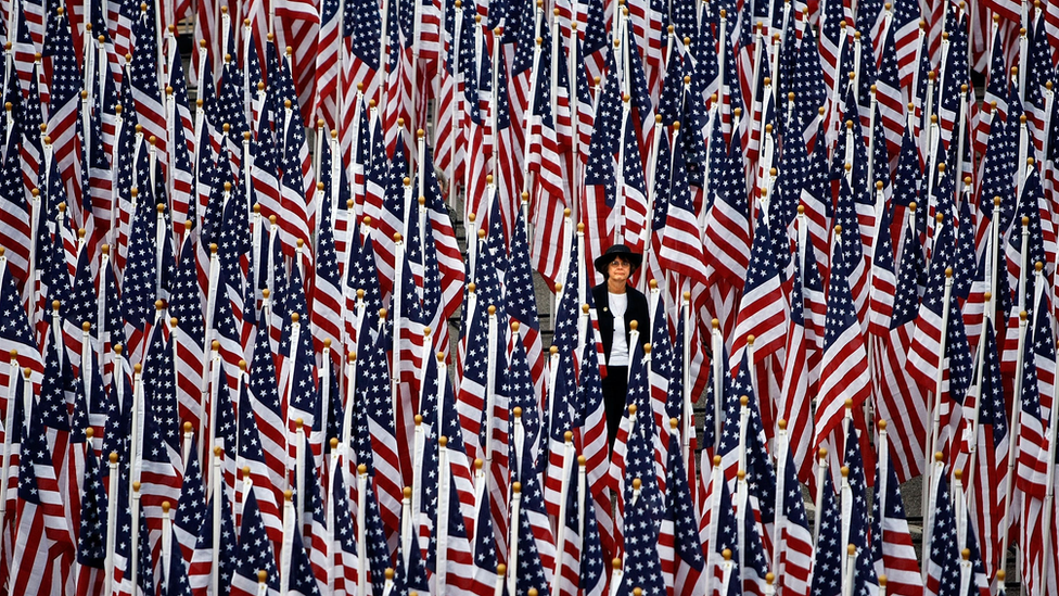 A woman walks through some of the nearly 3000 United States flags that make up the "Healing Field" outside the Pentagon during the dedication of the Pentagon Memorial September 11, 2008 in Arlington, Virginia.