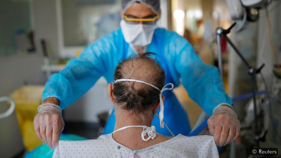 Doctor examines a patient sitting with his back to the camera