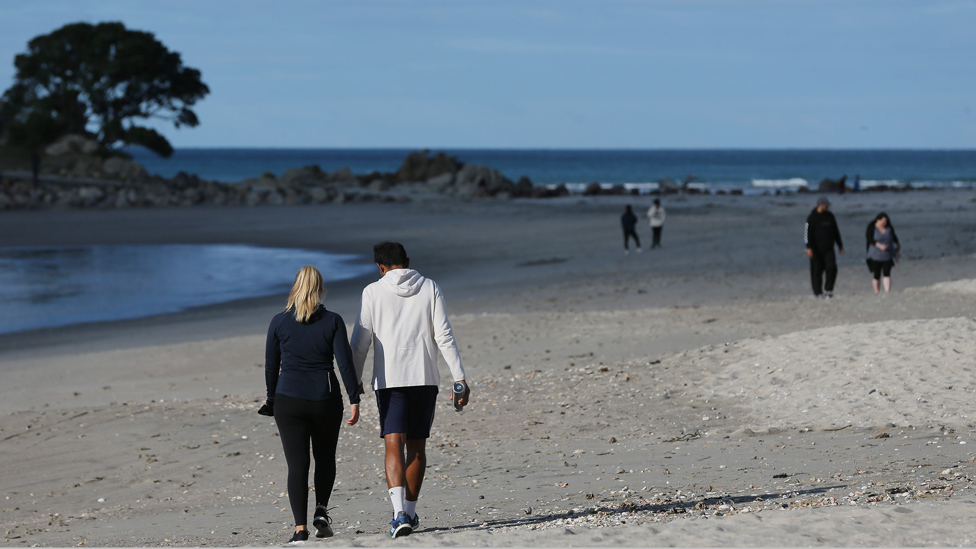 People walking on a beach in New Zealand