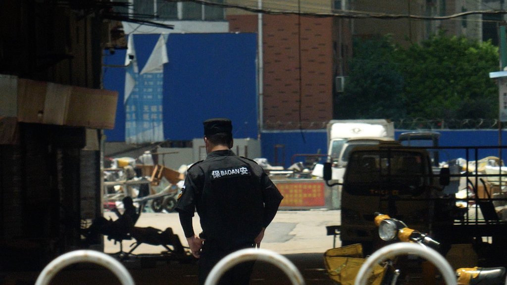 Policajac ispred pijace u Vuhanu