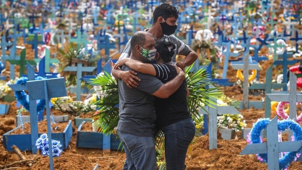 Korona virus: Zašto ljudi više ne mare za smrti i nove slučajeve zaraženih 3 Three people hug at a cemetery