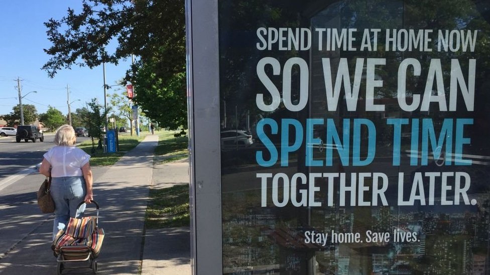 A street display shows a social distancing message in the Canadian city of Toronto