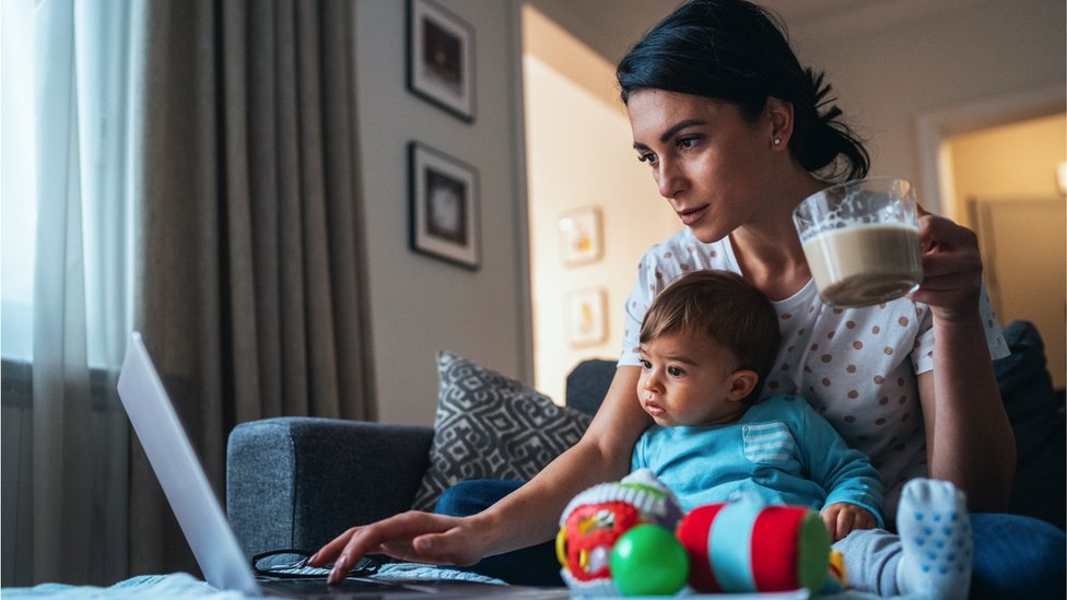 Korona virus i jednakost polova: Hoće li žene posle epidemije morati više da se trude na poslu 2 A woman working from home with a baby sitting between her and her computer