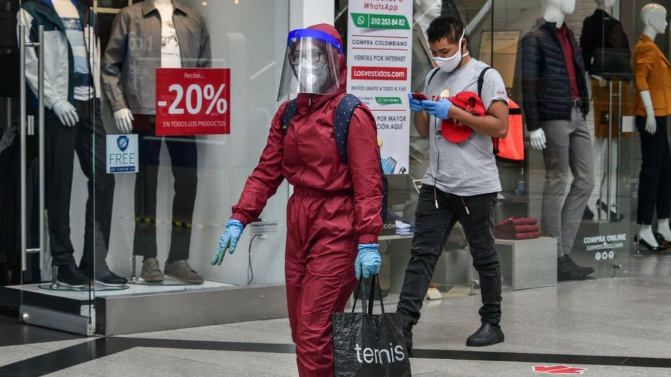 Korona virus i jednakost polova: Hoće li žene posle epidemije morati više da se trude na poslu 7 A woman wearing a biosafety suit walks holding a shopping bag at the Unicentro shopping center in Bogota, Colombia on July 01, 2020.