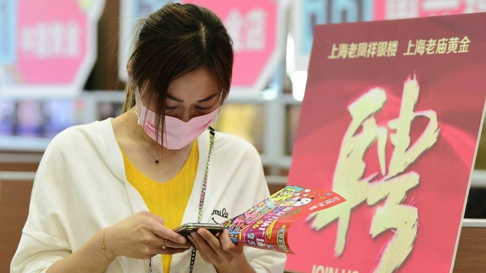 Korona virus i jednakost polova: Hoće li žene posle epidemije morati više da se trude na poslu 3 A woman checking information on her phone during a job fair in Hai'an City, Jiangsu Province, China, in May 2020