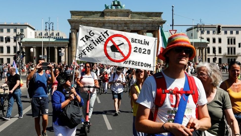 Demonstrators at the Brandenburg Gate with a banner reading Day of Freedom