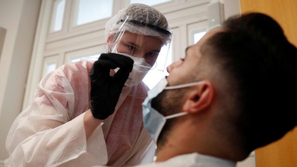 Health worker tests someone for coronavirus in Paris