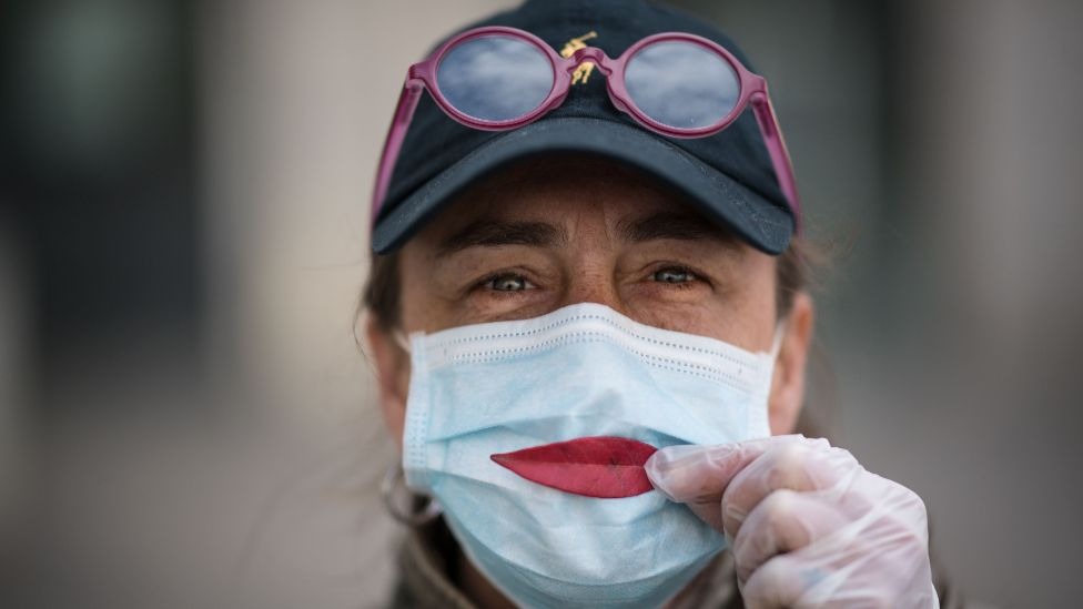 Korona virus i alternativna budućnost: Kako bi Srbija i svet izgledali da pandemija potraje pet godina 5 A woman wearing a protective mask holds a leaf as a smile in France, on 29 March 2020