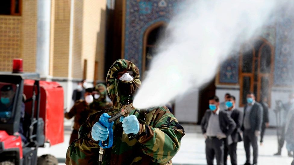 Korona virus: Šta znači „spljoštiti krivu“ širenja i zašto je to ključno 1 A member of the Iraqi civil defense sprays disinfectant on and around the Great Mosque of Kufa
