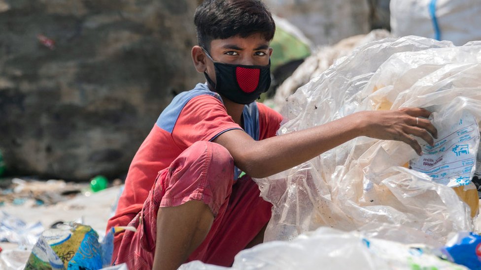 Korona virus nije pandemija već sindemija, kažu naučnici - šta to znači 2 A boy wearing a face mask rummages through garbage in Bangladesh