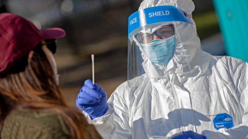 Korona virus: Usvojene nove mere u Srbiji, nove bolnice ulaze u kovid sistem, crni rekord u Americi 1 A test being conducted by a worker in PPE