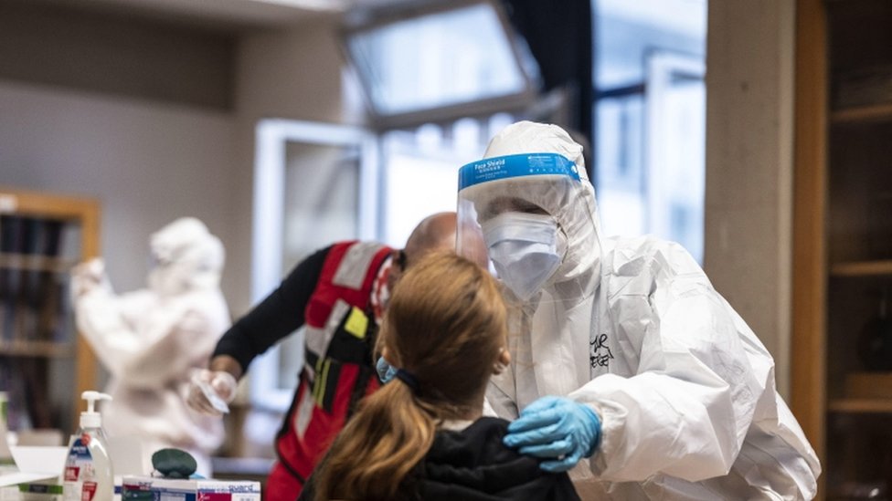 Korona virus: Krizni štab u Srbiji razmatra još strože mere, Francuska polako ukida ograničenja 2 A health worker wearing overalls and a protective mask performs a swab test on a student in Florence, Italy