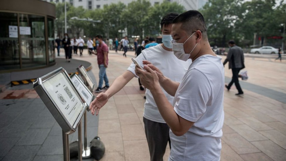 Korona virus i putovanja: Kina predlaže uvođenje sistema QR kodova za praćenje zdravlja putnika na svetskom nivou 2 Men in China using QR codes.