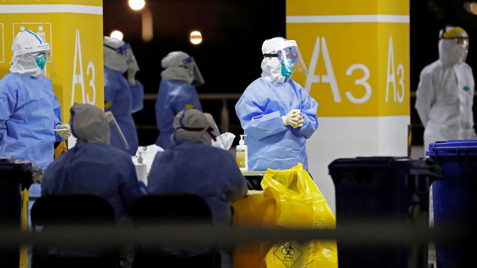 Korona virus: Krizni štab u Srbiji razmatra još strože mere, Francuska polako ukida ograničenja 1 Workers in protective suits are seen at a makeshift nucleic acid testing site inside carpark at Shanghai Pudong International Airport