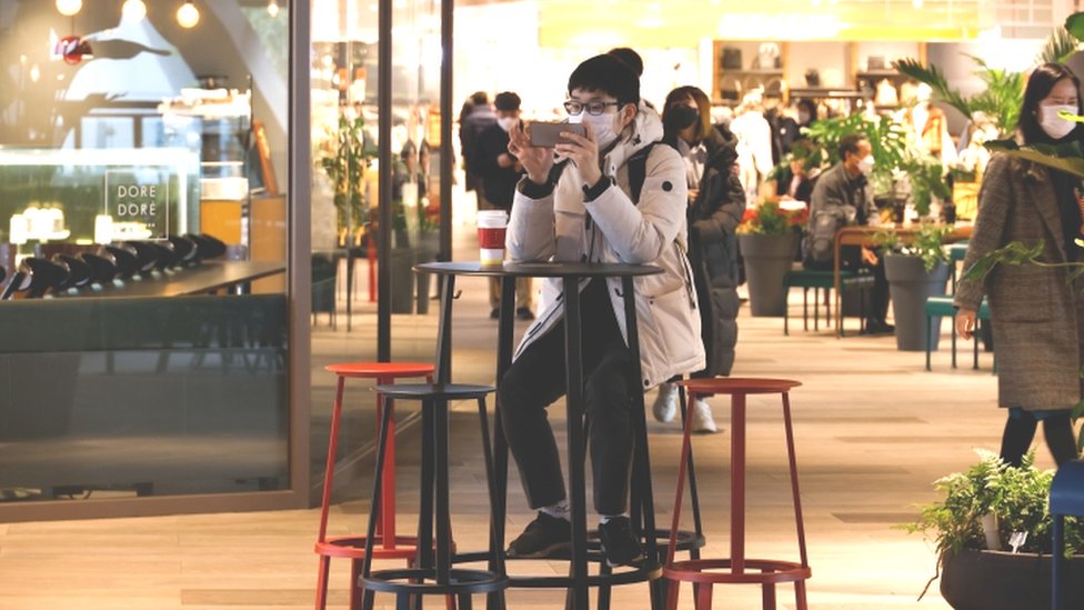 Korona virus: U Srbiji sve više pacijenata sa težom kliničkom slikom, Britanija započela vakcinaciju stanovništva 5 Man uses mobile phone in shopping mall in Seoul - 2 December