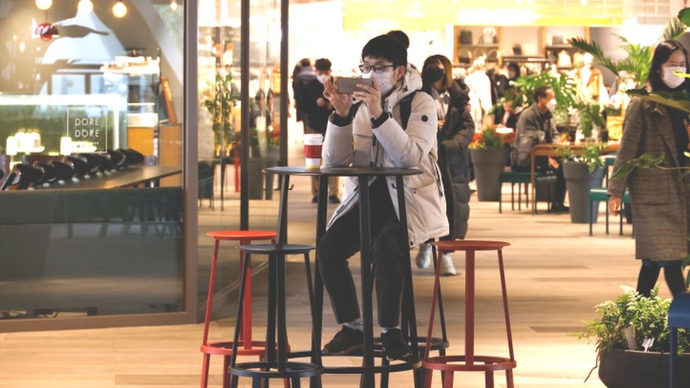 Man uses mobile phone in shopping mall in Seoul - 2 December