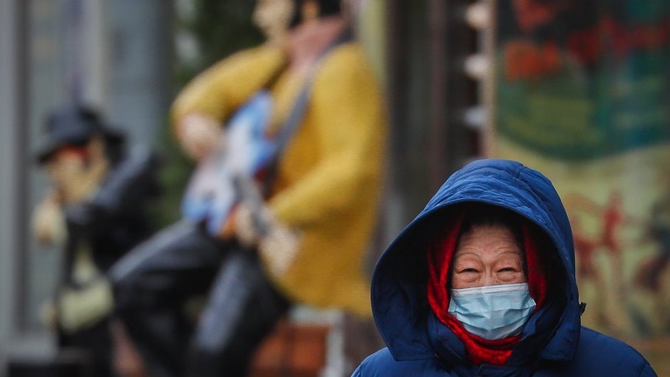 A woman wearing protective face mask walks on the street during pandemic of SARS-CoV-2 coronavirus in Moscow, Russia 18 November 2020
