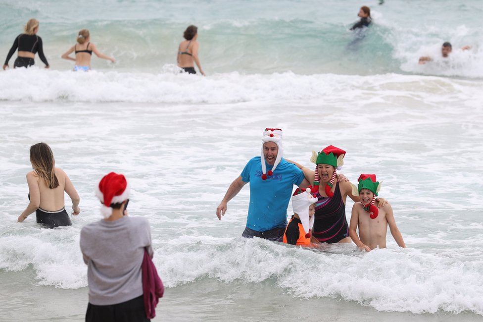 People wear Christmas-themed attire at Bondi Beach in Sydney, Australia. Photo: 25 December 2020