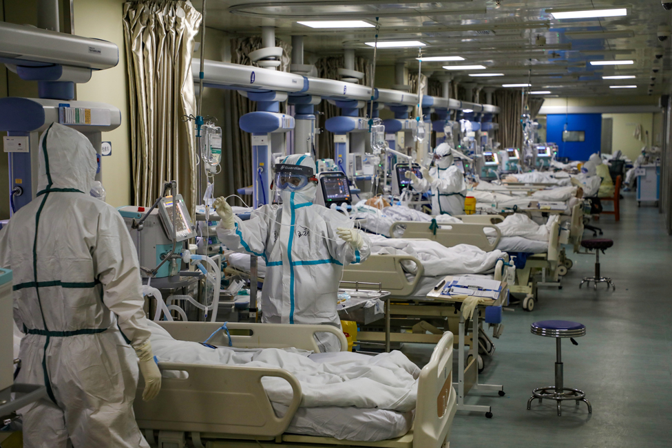 Medical workers in protective suits attend to Covid-19 patients at an intensive care unit in Wuhan, Hubei province, China, 6 February 2020
