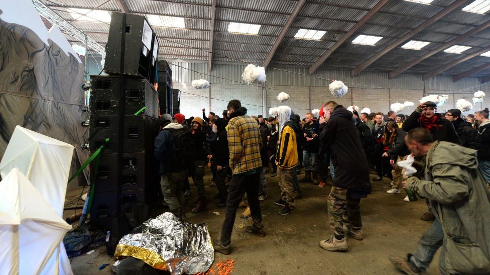 Korona virus i Francuska: Više hiljada ljudi na nelegalnom rejvu, napali policiju na žurci 2 People stand in front of speakers inside the warehouse