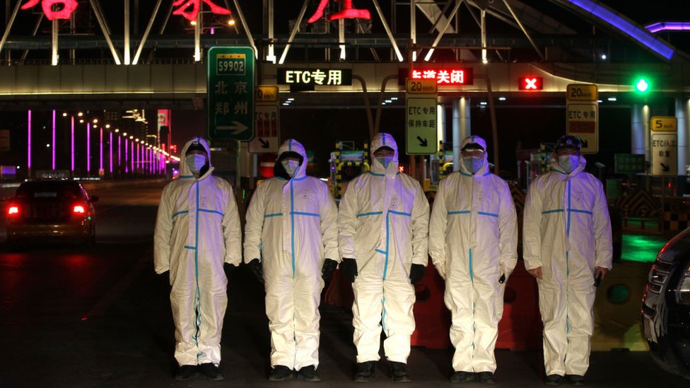 Police wearing protective suits block a road in the Chinese city of Shijiazhuang, January 2021