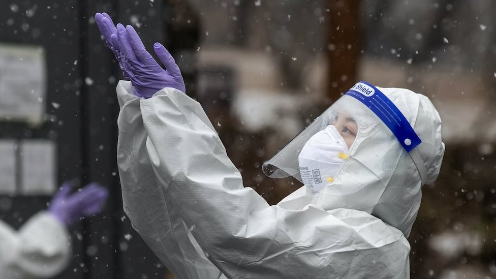 A health worker wearing a protective suit enjoys falling snow at a coronavirus disease (COVID-19) testing site in Seoul, South Korea, January 12, 2021.