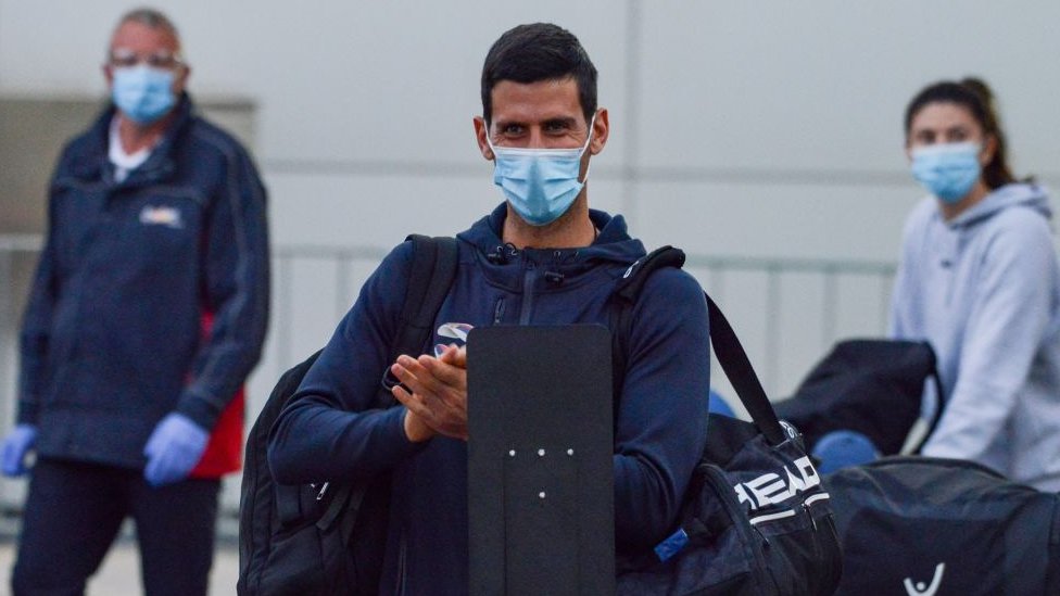 Novak Djokovic wearing a mask at Adelaide Airport on his way to hotel quarantine