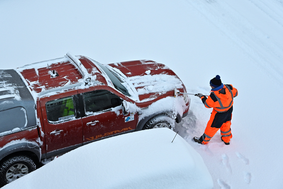 A man clears snow from his truck in a car park in Dalgety Bay, Fife, on 9 February 2021