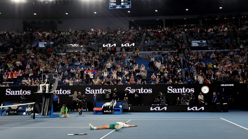 Crowd of tennis spectators cheer on Novak Djokovic after his winning point in the Australian Open 2021 grand final