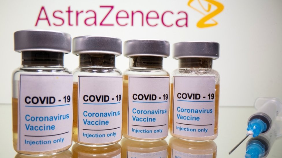 Korona virus: U Srbiji na snazi nove mere, vakcina AstraZeneka potpuno bezbedna - studija u SAD 4 Vials with a sticker reading, "COVID-19 / Coronavirus vaccine / Injection only" and a medical syringe in front of a displayed AstraZeneca logo