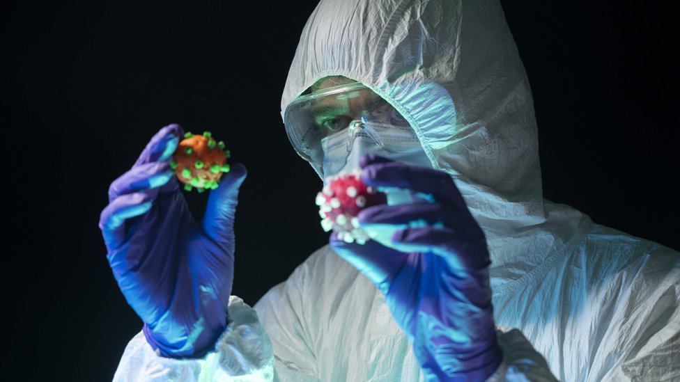 Korona virus: Osam stvari koje smo naučili u protekloj godini pandemije 10 A doctor holding two models of the virus