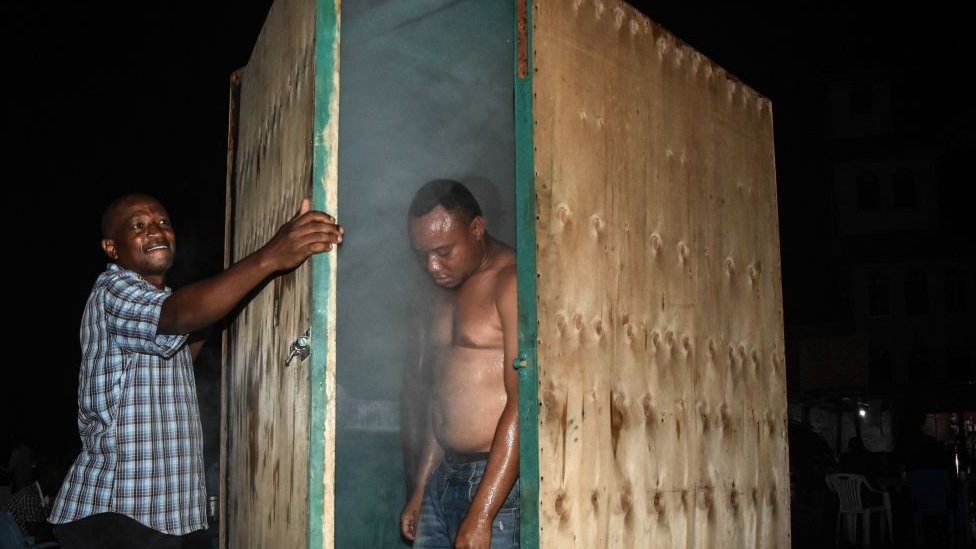A man leaves a steam inhalation booth installed by a herbalist in Dar es Salaam, Tanzania, on 22 May 2020
