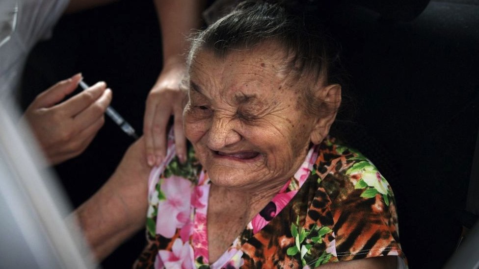 A Brazilian elderly woman receives a dose of the Coronavac vaccine at a drive through vaccination center at the Sambodrome Rio Carnival venue, in Rio de Janeiro, Brazil, on February 6, 2021.