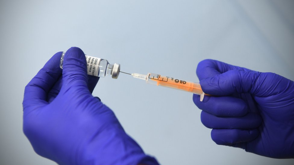 Korona virus i vakcine: Zašto bogate zemlje „blokiraju“ proizvodnju zemljama u razvoju 3 Gloved hands drawing AstraZeneca vaccine from a vial with a syringe