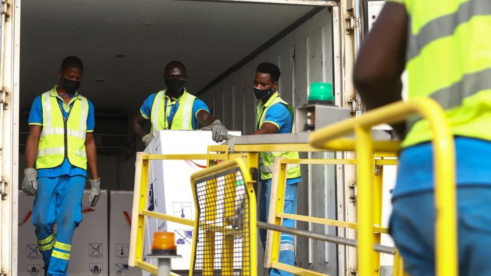 Korona virus: Kada će svet biti vakcinisan 6 Men in hi-vis jackets dealing with a vaccine delivery