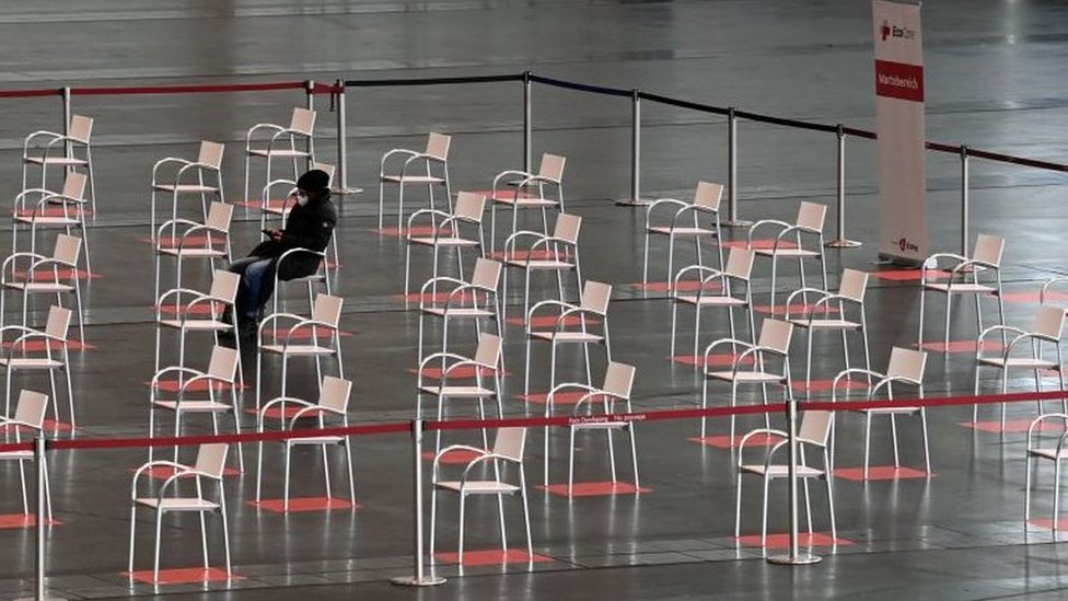 Korona virus: Kada će svet biti vakcinisan 8 A person sits in the waiting area of a vaccination centre in Nuremberg, southern Germany