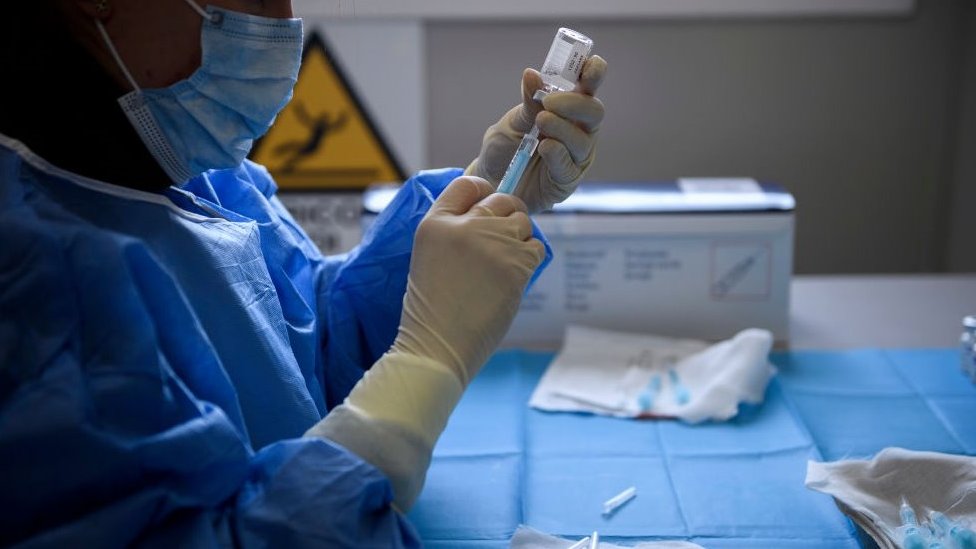 Korona virus: Kada će svet biti vakcinisan 9 A person in PPE draws the vaccine from a vial into a syringe
