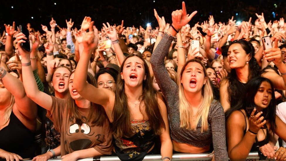Korona virus: Kada će svet biti vakcinisan 10 Young women cheering in the crowd at a music event
