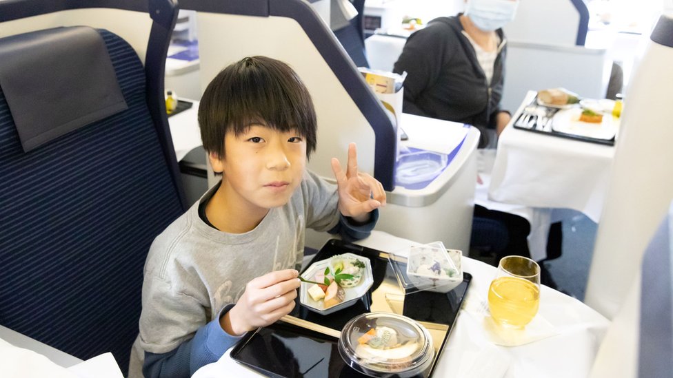 Child eating meal on plane