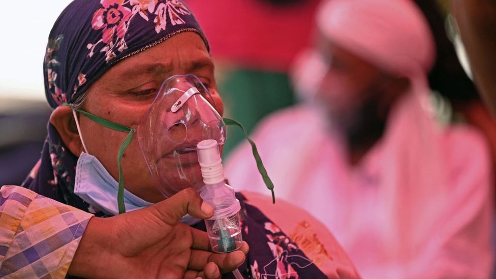 Korona virus i Indija: Zašto čitavom svetu treba da je stalo do zdravstvene krize u jednoj od najmnogoljudnijih zemalja 6 Patients breathe with the help of oxygen provided by a Gurdwara, a place of worship for Sikhs, under a tent installed along the roadside amid Covid-19 coronavirus pandemic in Ghaziabad on April 26, 2021.