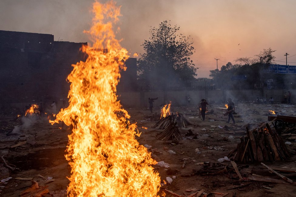 Funeral pyres burn in a crematorium in New Delhi, India