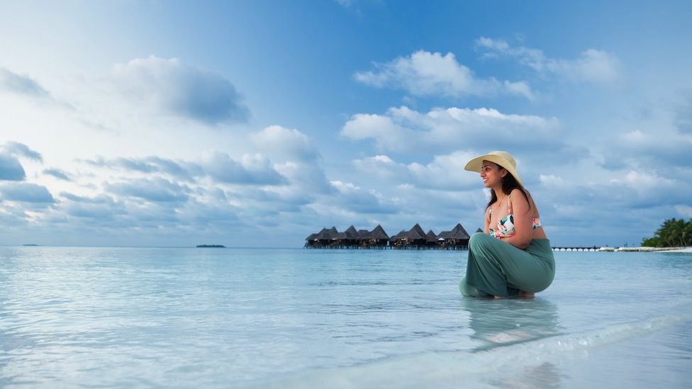 A woman enjoying the blue sea in an afternoon in the Maldives - stock photo
