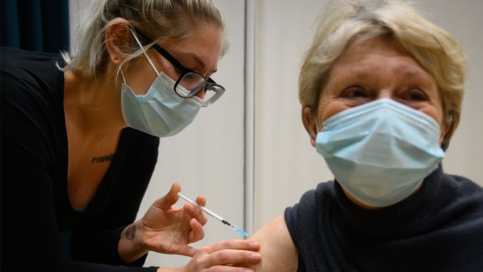 Korona virus: Osniva se Radna grupa za ispitivanje smrtnih slučajeva u Srbiji, neke zemlje prinuđene da bace neiskorišćene vakcine 1 Woman receives Covid vaccine at centre in Surrey