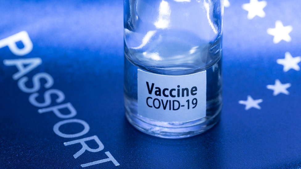 Image shows a vaccine vial reading "Covid-19 vaccine" on an European passport