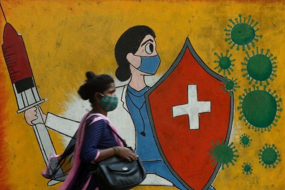 Korona virus: Prvi dan u Srbiji bez preminulih od septembra, SZO upozorava Evropu na novi talas zbog EURO2020 1 A woman walks past a graffiti on a street, amidst the spread of the coronavirus disease (COVID-19) in Mumbai, India, May 10, 2021.