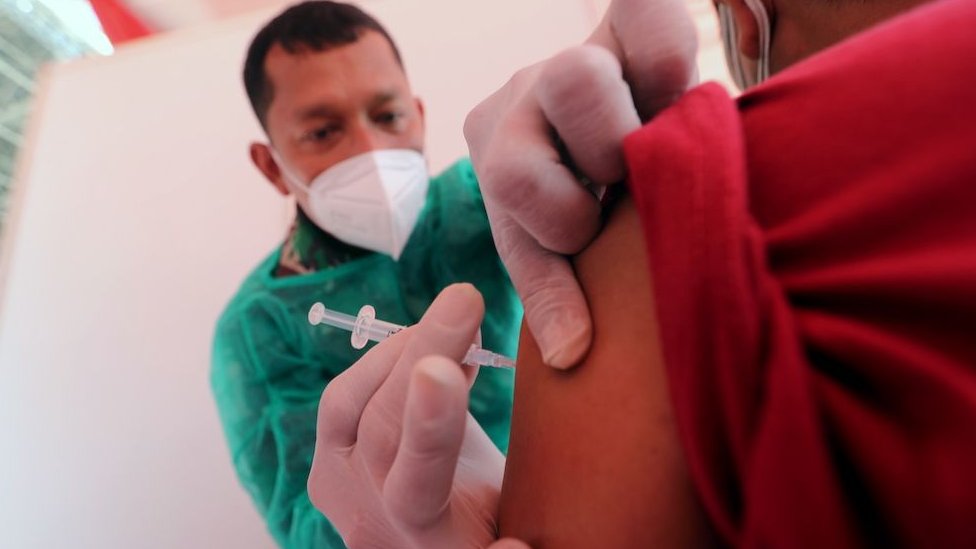 Korona virus i kineske vakcine: Sinovak i Sinofarm - koliko su delotvorni 1 An Indonesian military doctor injects a dose of Sinovac COVID-19 vaccine made by Biofarma to a man during a COVID-19 vaccination drive at Gelora Bung Karno Stadium in Jakarta, Indonesia, 26 June 2021