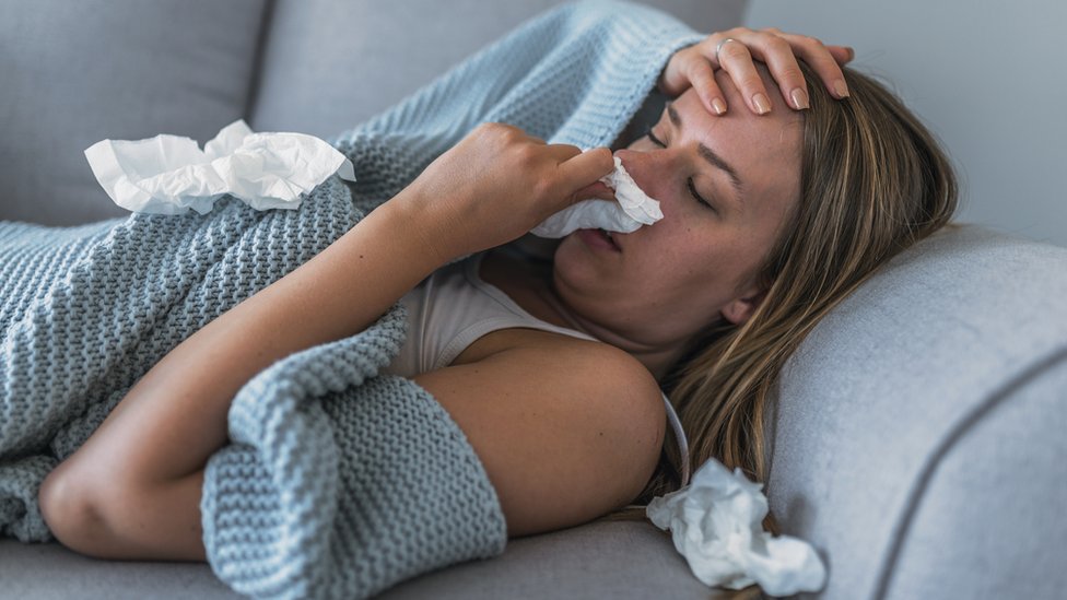 Korona virus: „Ne pričajte o čipovanju vakcinama, ubićete nekog" - kaže Vučić, protesti u Grčkoj i Francuskoj, Melburn u novom karantinu 1 Women ill at home on the sofa with flu